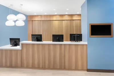 a lobby with a counter with a tv on the wall at Element Times Square West in New York