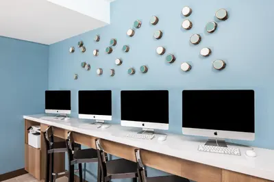 a desk with four computer monitors on a blue wall at Element Times Square West in New York