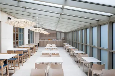 a cafeteria with tables and chairs and windows at Element Times Square West in New York