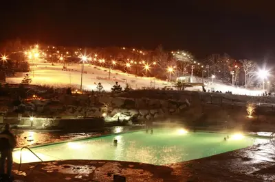 a swimming pool in a park at night at The Appalachian at Mountain Creek in Vernon