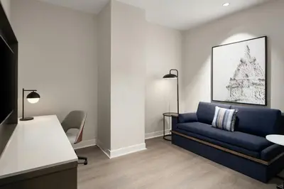 a living room with a blue couch and a table at Courtyard by Marriott Philadelphia Downtown in Philadelphia