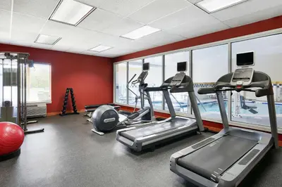 a gym with treadmills and ellipticals in a building at Hilton Garden Inn Allentown West in Breinigsville