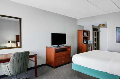 a bedroom with a bed and a desk with a television at Hilton Garden Inn Allentown West in Breinigsville