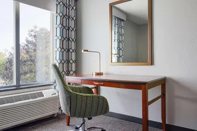 a desk in a room with a chair and a mirror at Hilton Garden Inn Allentown West in Breinigsville