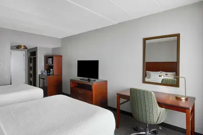 a hotel room with a bed and a desk with a television at Hilton Garden Inn Allentown West in Breinigsville