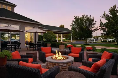 a patio with a fire pit and chairs and tables at Hilton Garden Inn Allentown West in Breinigsville