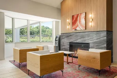 a living room with a fireplace and some chairs at Ramada by Wyndham Allentown Bethlehem in Allentown