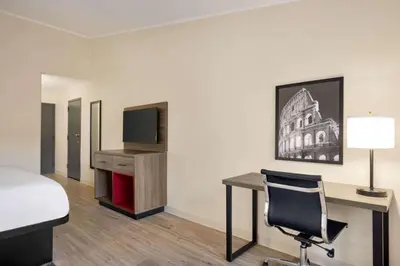 a hotel room with a bed and a desk and a tv at Ramada by Wyndham Allentown Bethlehem in Allentown