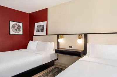 a hotel room with two beds and red walls at Ramada by Wyndham Allentown Bethlehem in Allentown