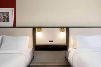 a hotel room with two beds and a mirror at Ramada by Wyndham Allentown Bethlehem in Allentown