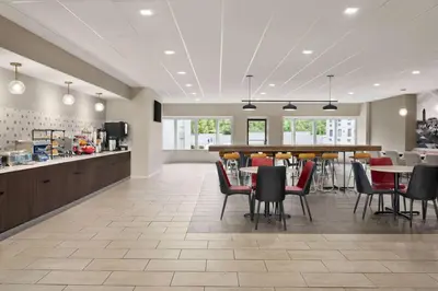 a restaurant with tables and chairs and a kitchen at Ramada by Wyndham Allentown Bethlehem in Allentown