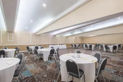 a banquet hall with white tables and chairs at Ramada by Wyndham Allentown Bethlehem in Allentown