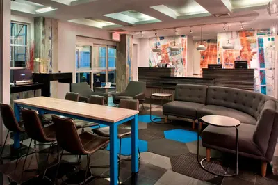 a waiting room with a table and chairs and a couch at Four Points by Sheraton Manhattan SoHo Village in New York