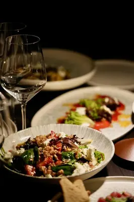 a table with plates of food and a glass of wine at Four Points by Sheraton Manhattan SoHo Village in New York