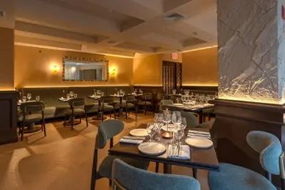 a restaurant with tables and chairs and a mirror at Four Points by Sheraton Manhattan SoHo Village in New York