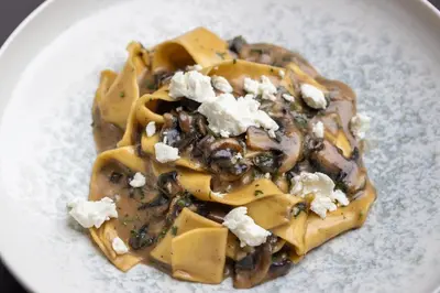 a white plate of food with cheese and mushrooms at Four Points by Sheraton Manhattan SoHo Village in New York