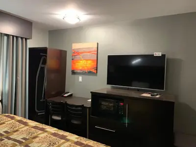 a hotel room with a flat screen tv and a bed at Red Carpet Inn Elmwood in Elmwood Park