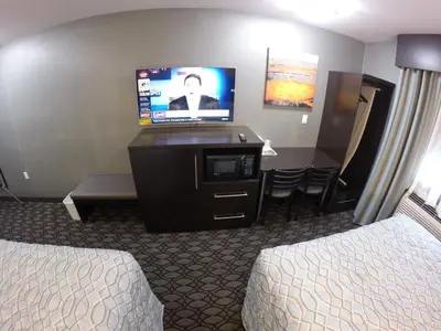 a hotel room with two beds and a flat screen tv at Red Carpet Inn Elmwood in Elmwood Park