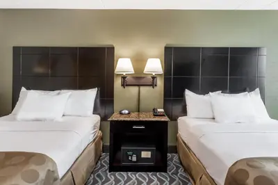 two beds in a hotel room with two lamps at Ramada by Wyndham Newburgh/West Point in Newburgh