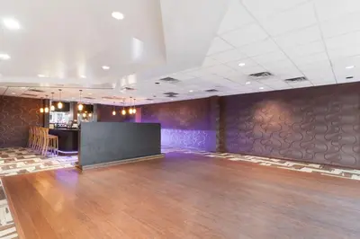 a large room with a stage in the middle of a dance floor at Ramada by Wyndham Newburgh/West Point in Newburgh