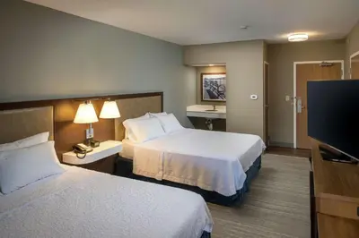 a hotel room with two beds and a flat screen tv at Hampton Inn & Suites Binghamton/Vestal in Vestal