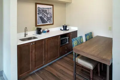 a kitchen with a sink and a table with chairs at Hampton Inn & Suites Binghamton/Vestal in Vestal
