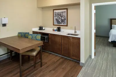 a kitchen with a table and a sink in a room at Hampton Inn & Suites Binghamton/Vestal in Vestal