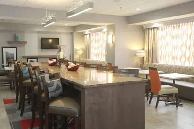 a lobby with a bar with chairs and a waiting room at Hampton Inn Owego in Owego
