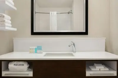 a bathroom with a sink and a mirror at Hampton Inn Binghamton/Johnson City in Binghamton