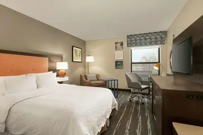 a hotel room with a bed and a flat screen tv at Hampton Inn Binghamton/Johnson City in Binghamton