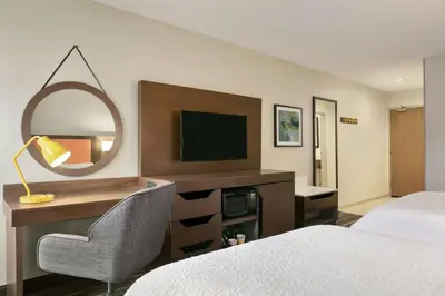 a hotel room with a bed and a mirror at Hampton Inn Binghamton/Johnson City in Binghamton
