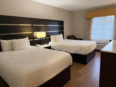 a hotel room with two beds and a window at Days Inn by Wyndham Budd Lake in Budd Lake
