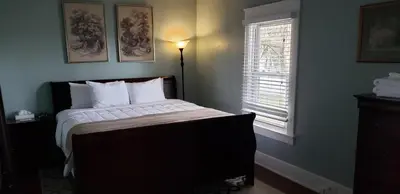 a bedroom with a bed with white sheets and a window at Allenberry Resort in Carlisle