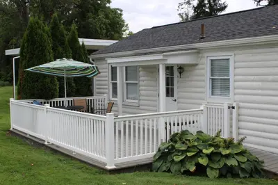 a white house with a white fence and an umbrella at Allenberry Resort in Carlisle