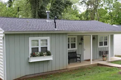 a shed with a porch and flowers in a yard at Allenberry Resort in Carlisle