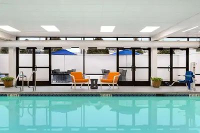 a swimming pool with chairs and a table at Hampton Inn Bloomsburg in Bloomsburg