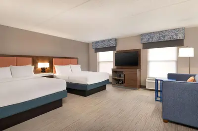a hotel room with two beds and a flat screen tv at Hampton Inn Bloomsburg in Bloomsburg