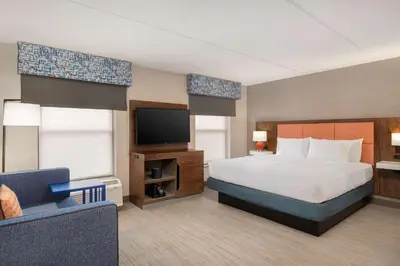 a hotel room with a bed and a flat screen tv at Hampton Inn Bloomsburg in Bloomsburg