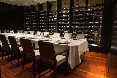 a long table in a room with a wine cellar at The Langham, New York, Fifth Avenue in New York
