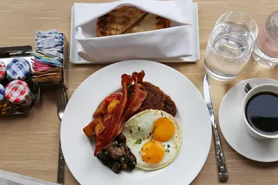 a plate of breakfast food with eggs bacon and toast at The Langham, New York, Fifth Avenue in New York