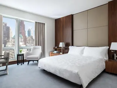 a hotel room with a bed and a chair at The Langham, New York, Fifth Avenue in New York