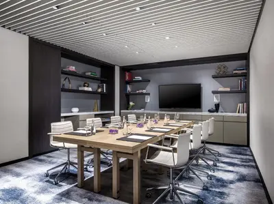 a conference room with a long table and white chairs at The Langham, New York, Fifth Avenue in New York