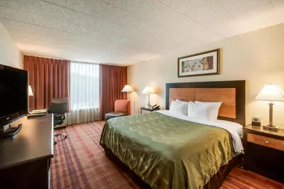 a hotel room with a bed and a flat screen tv at Chester Hotel and Conference Center in Exton