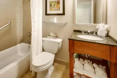 a bathroom with a toilet and a sink and a tub at Chester Hotel and Conference Center in Exton