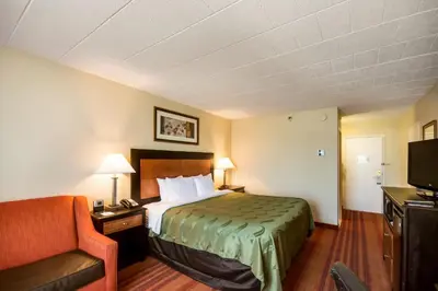 a hotel room with a bed and a chair at Chester Hotel and Conference Center in Exton