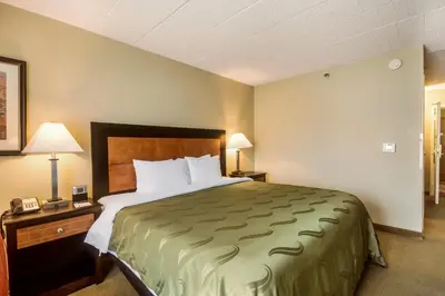 a hotel room with a large bed and two lamps at Chester Hotel and Conference Center in Exton