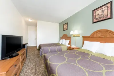 a hotel room with two beds and a flat screen tv at Knights Inn Palmyra in Palmyra