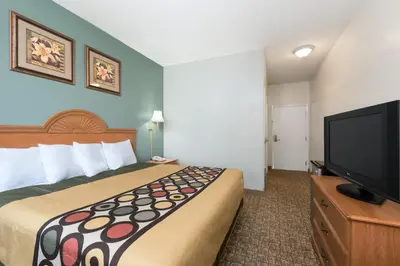 a hotel room with a bed and a flat screen tv at Knights Inn Palmyra in Palmyra