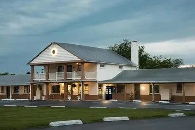 a large white building with a porch at Knights Inn Palmyra in Palmyra