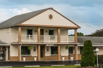 a large white building with a balcony at Knights Inn Palmyra in Palmyra